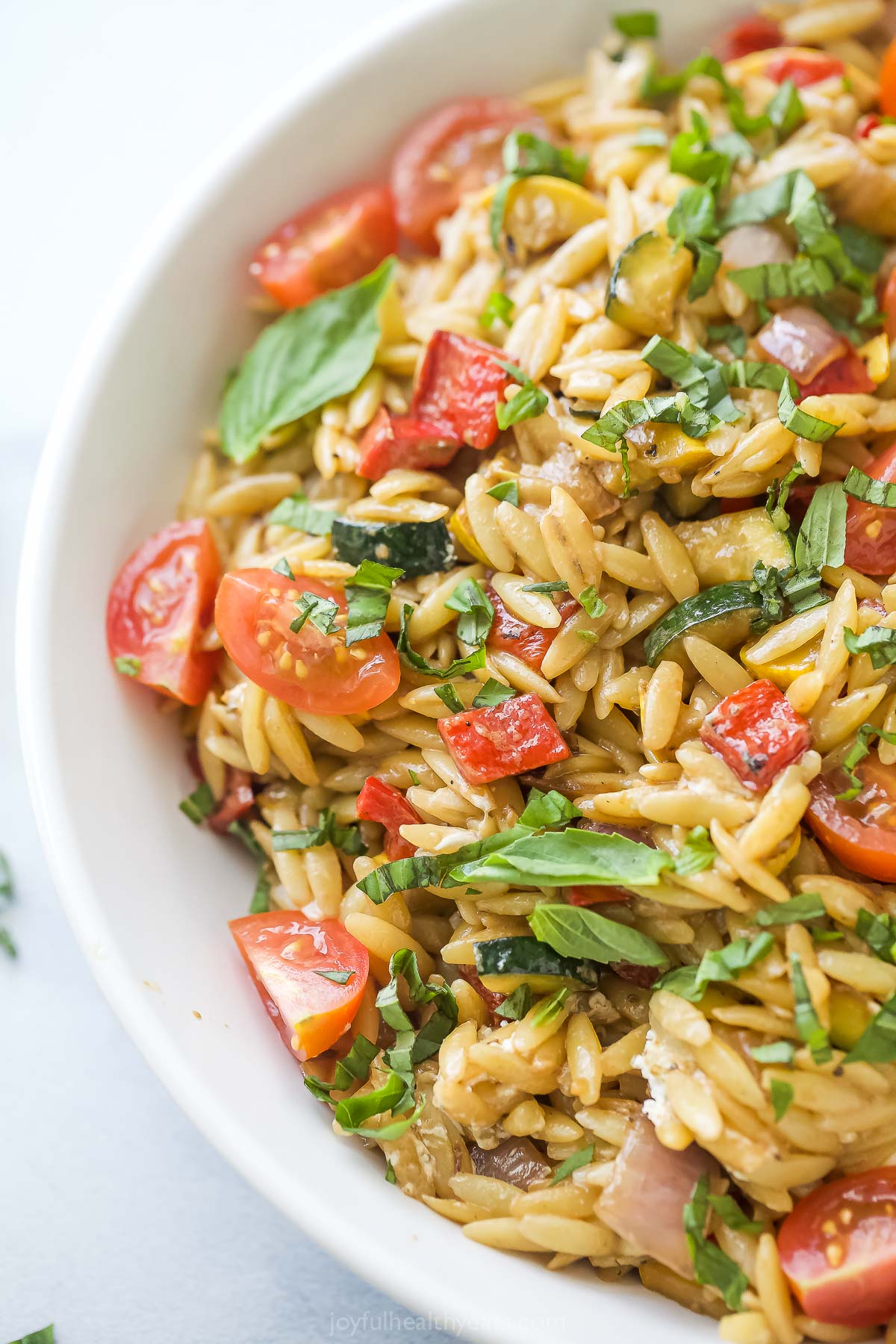 Close-up of orzo salad with veggies and homemade tangy dressing. 