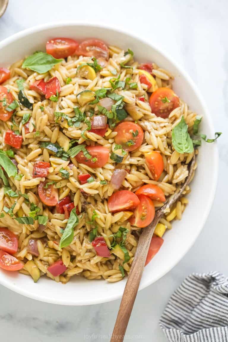 Angled photo of homemade orzo salad with dressing.