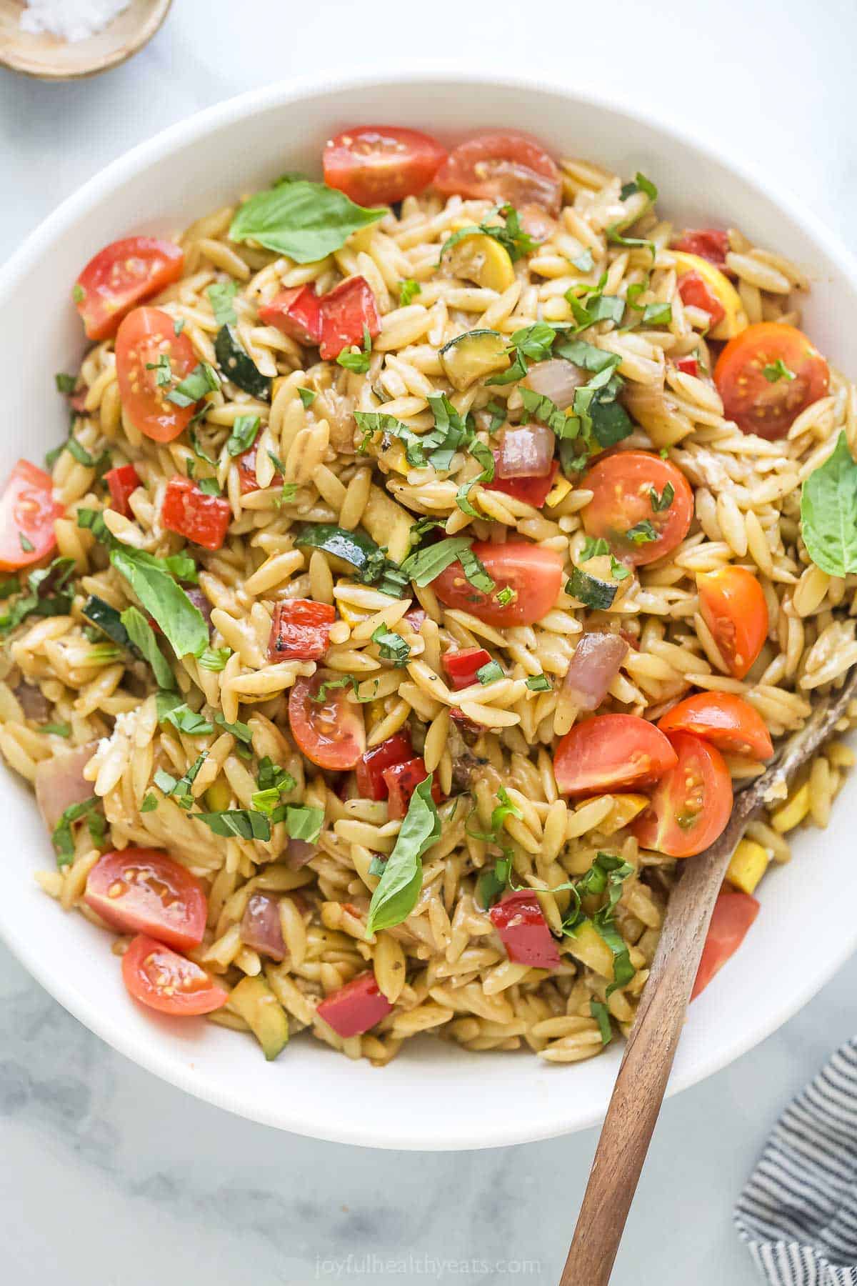 Bowl of orzo pasta salad with grilled veggies and balsamic dressing. 