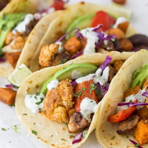 Close-up of the tacos with avocado, red cabbage, and homemade crema on top.