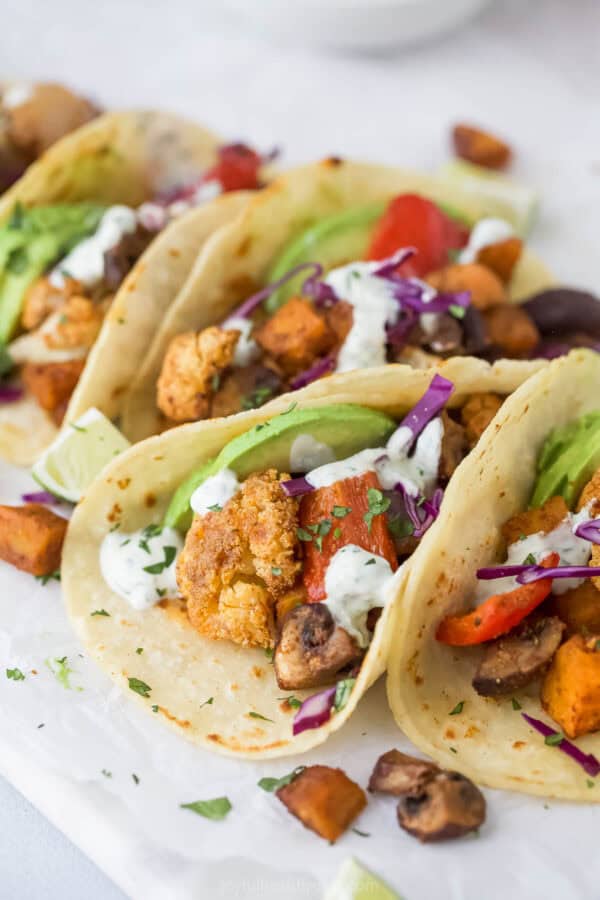 Close-up of Tacos with Avocado, Red Cabbage and Homemade Krema on top.