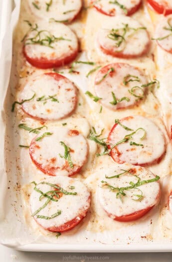 Freshly baked tomatoes with mozzarella, parmesan, olive oil, and basil.