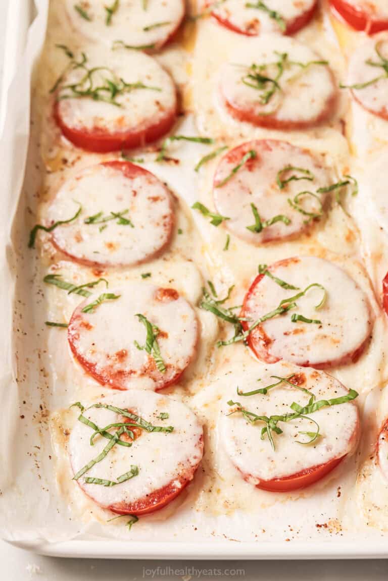 Freshly baked tomatoes with mozzarella, parmesan, olive oil, and basil.