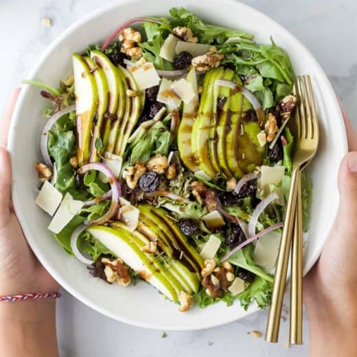 Bowl of my holiday pear salad with walnuts, cherries, parmesan, and balsamic vinaigrette.