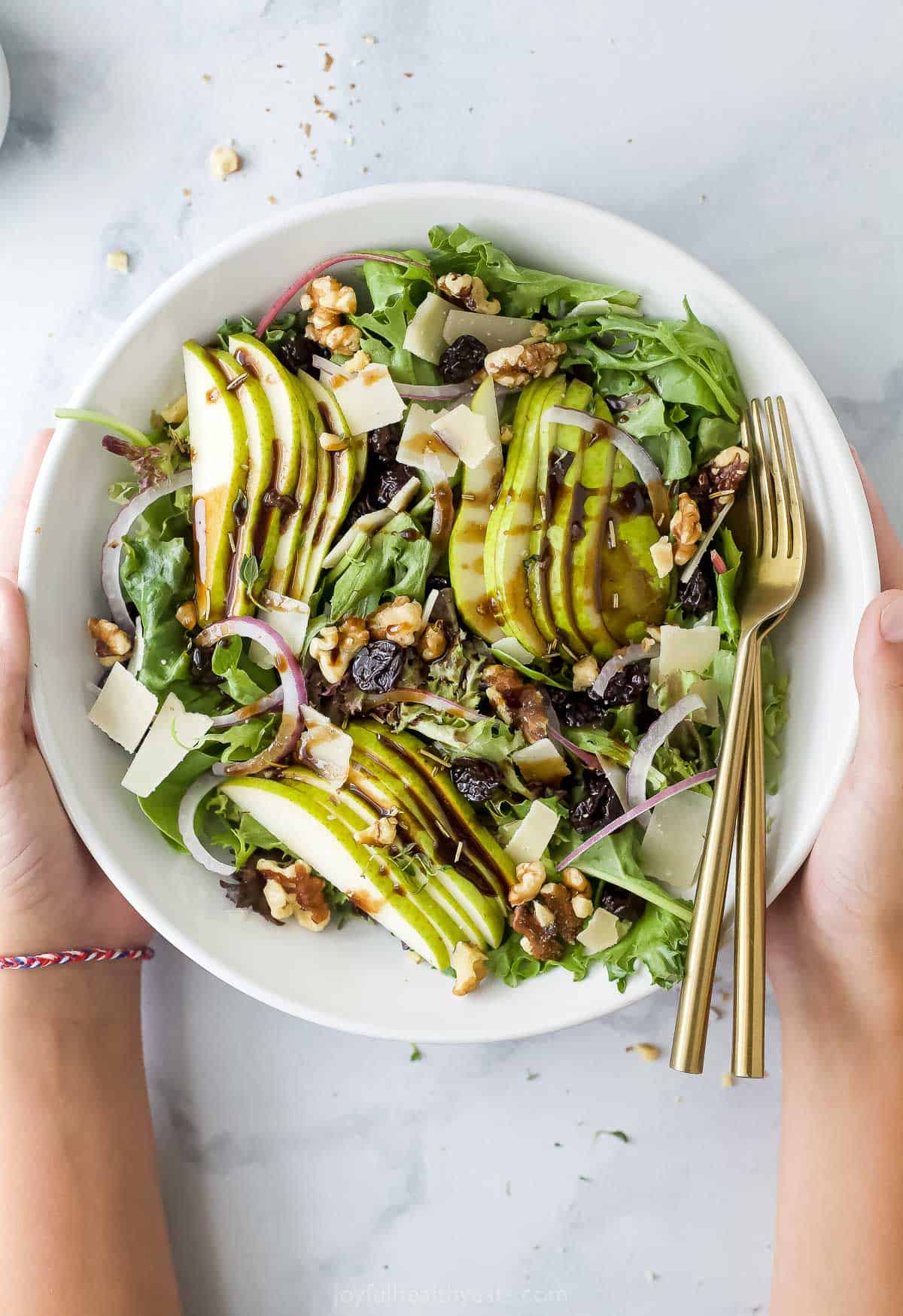 Bowl of my holiday pear salad with walnuts, cherries, parmesan and balsamic vinaigrette.