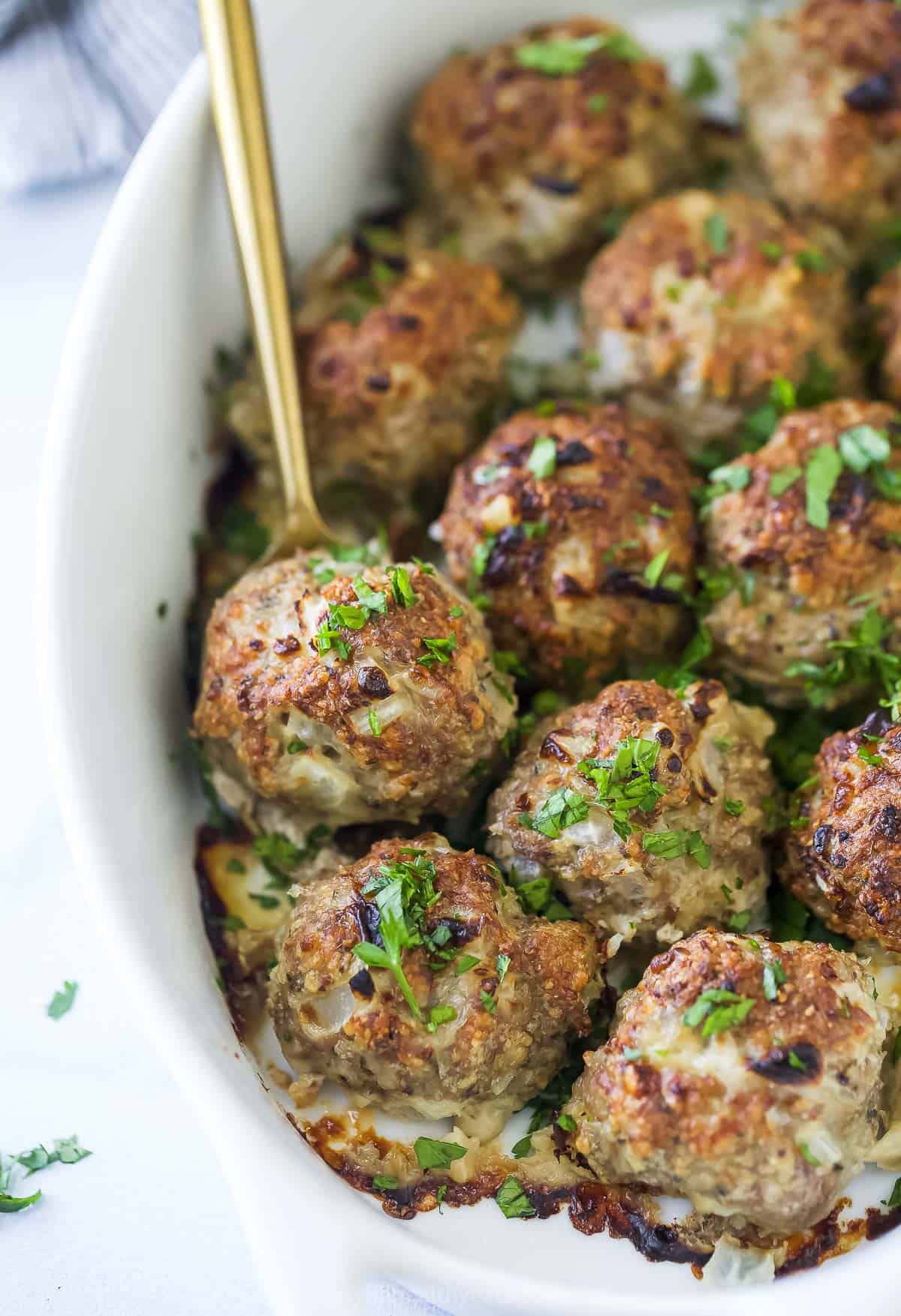 Close-up of baked meatballs with fresh parsley on top. 