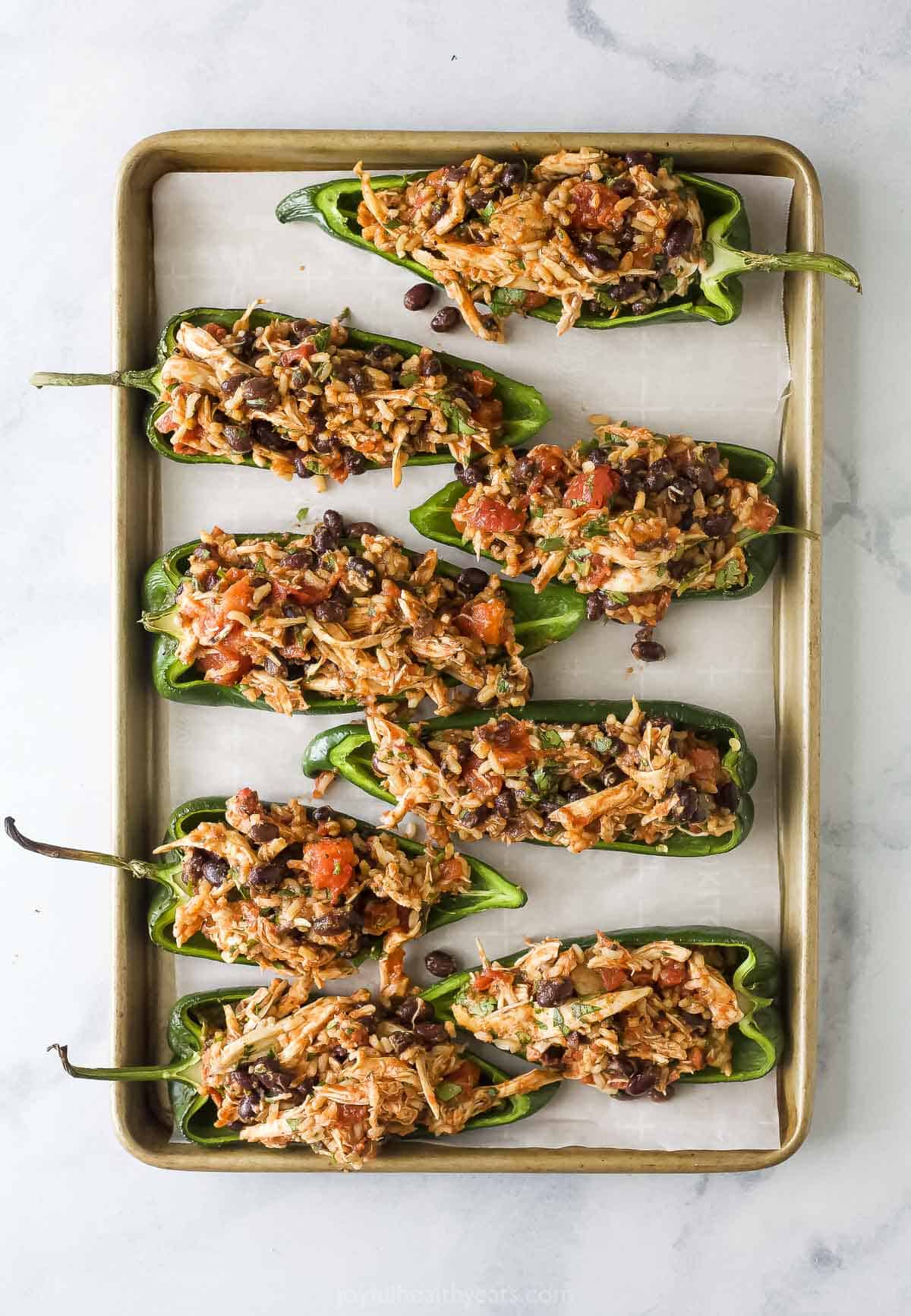 Stuffed peppers on the baking sheet.