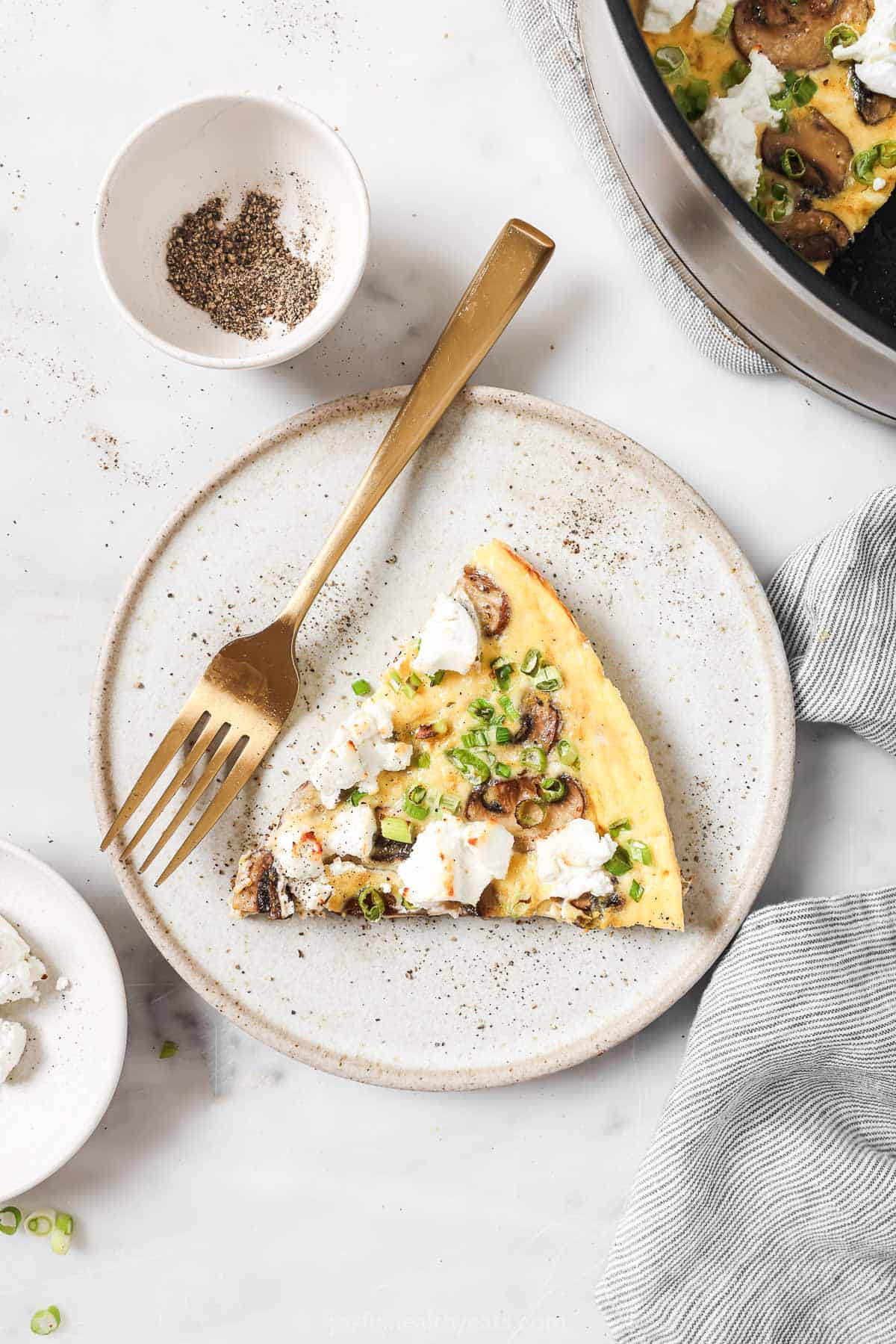 Homemade frittata slices with green onions, creamy goat cheese and mushrooms. 