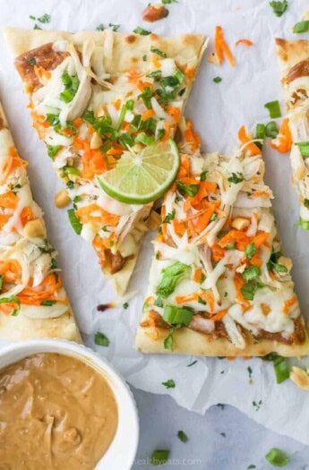 Sliced Thai chicken pizza with fresh cilantro on top.