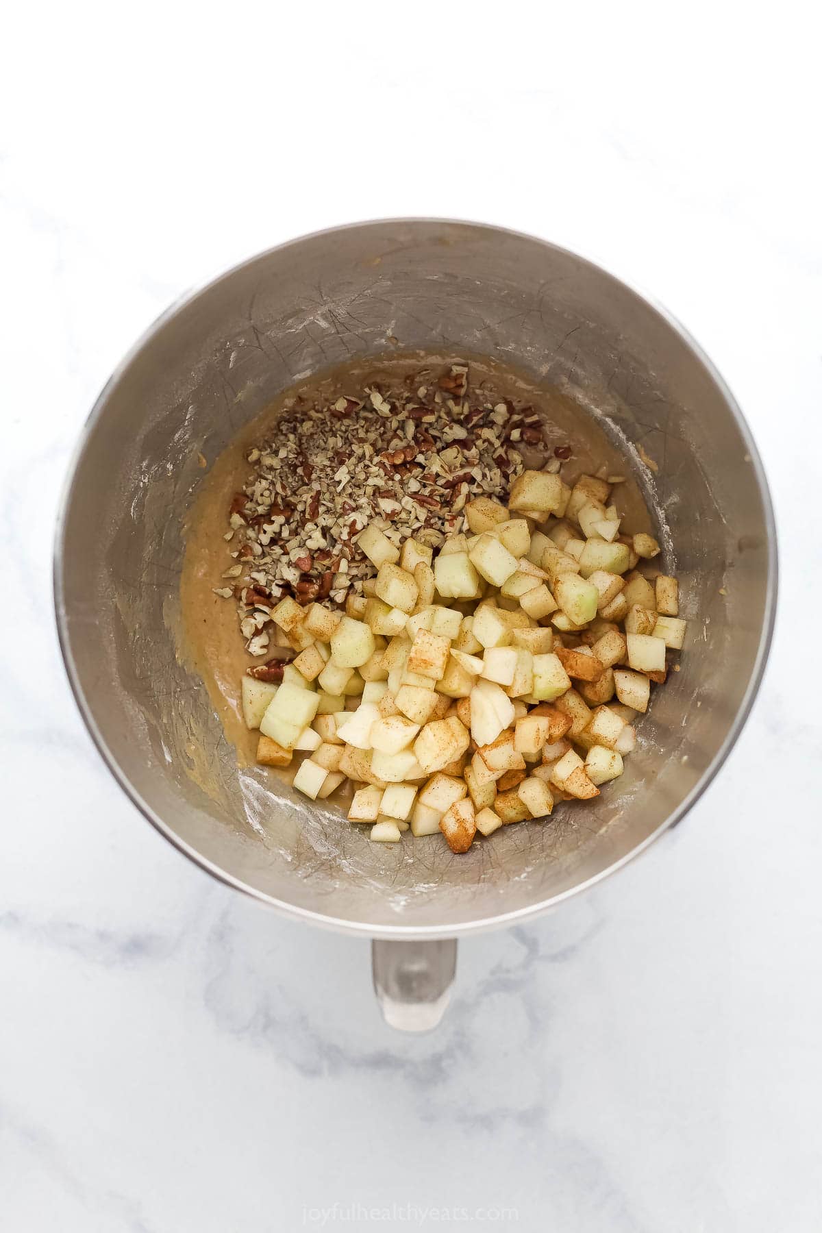 Folding the apples and pecans into the batter.