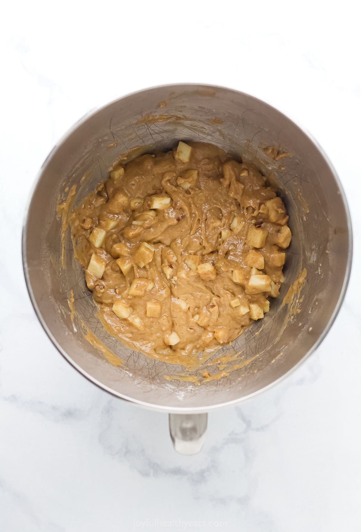 Loaf batter with apples and pecans in a bowl. 