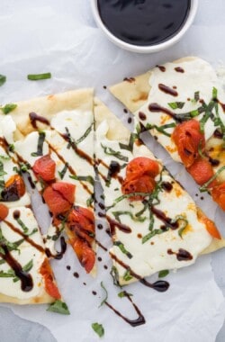 Caprese flatbread with mozzarella, roasted tomatoes, fresh basil, and balsamic reduction.