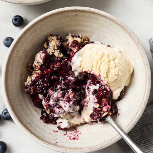 Bowl of blueberry cobbler with vanilla ice cream.