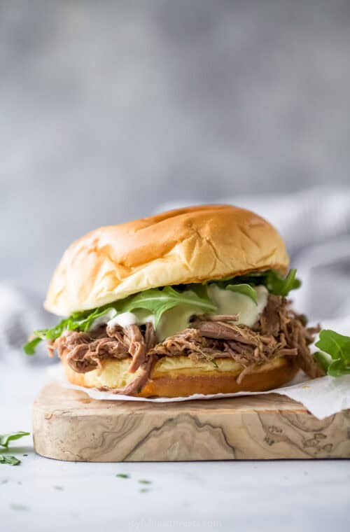 Homemade shredded beef sandwich with arugula, horseradish aioli, and melty provolone cheese.