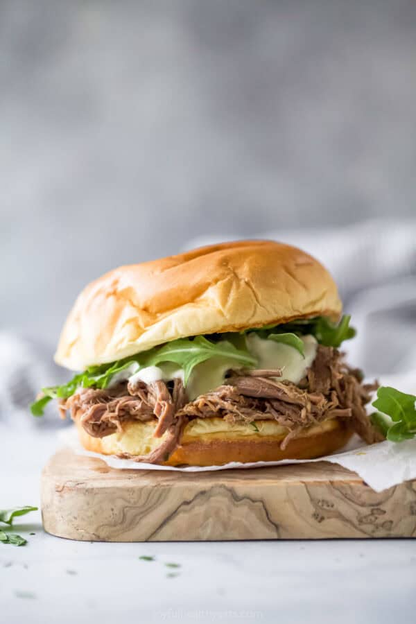 Homemade sliced ​​beef sandwich with arugula, horseradish aioli and melted provolone cheese.