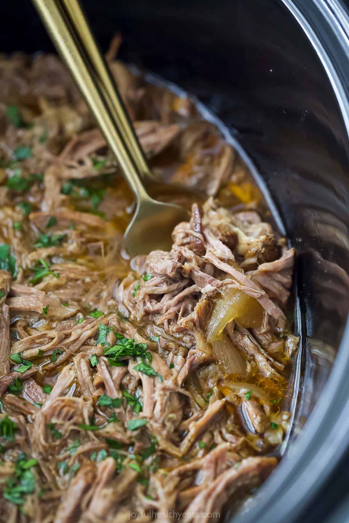 Close-up of the juicy shredded beef in the crockpot. 