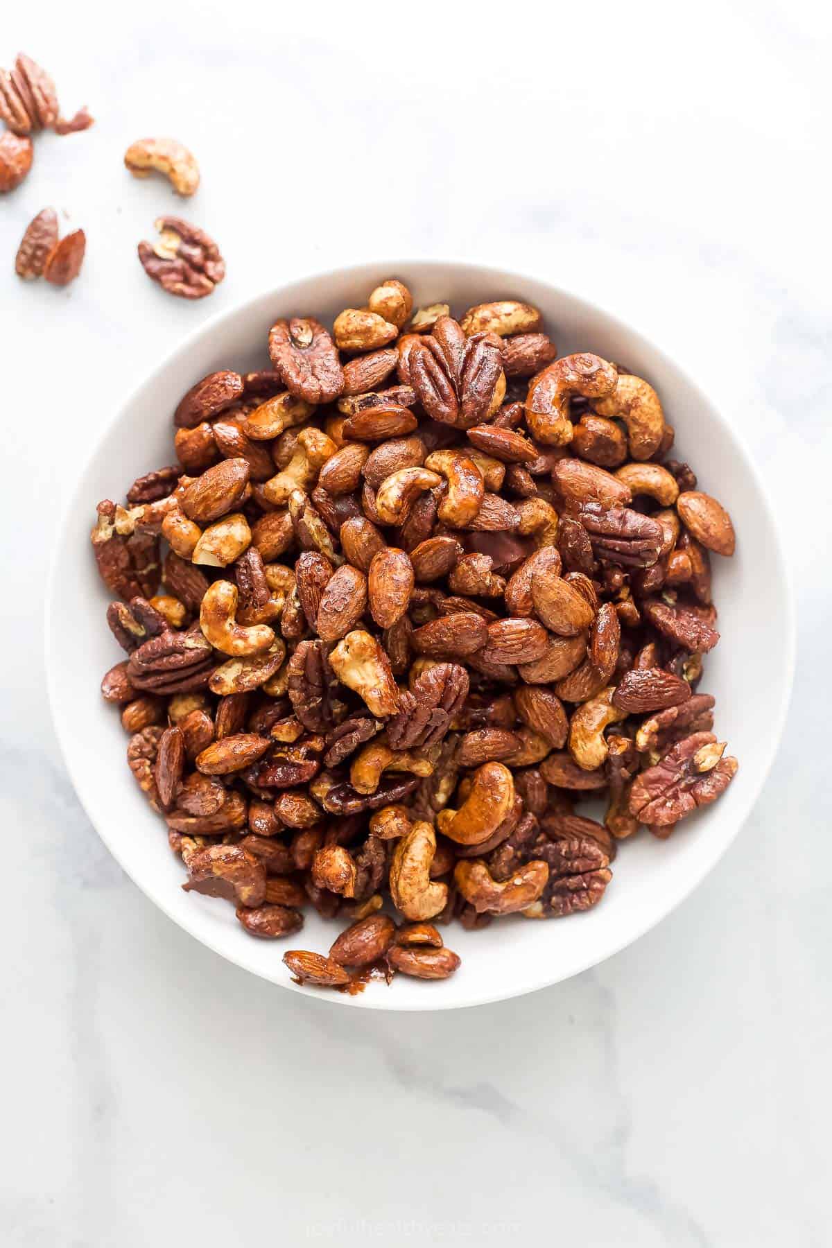 A bowl of homemade maple syrup spiced candied nuts. 