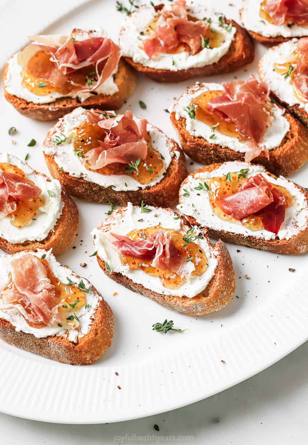 Close-up of homemade crostinis with goat cheese, fig jam and prosciutto. 