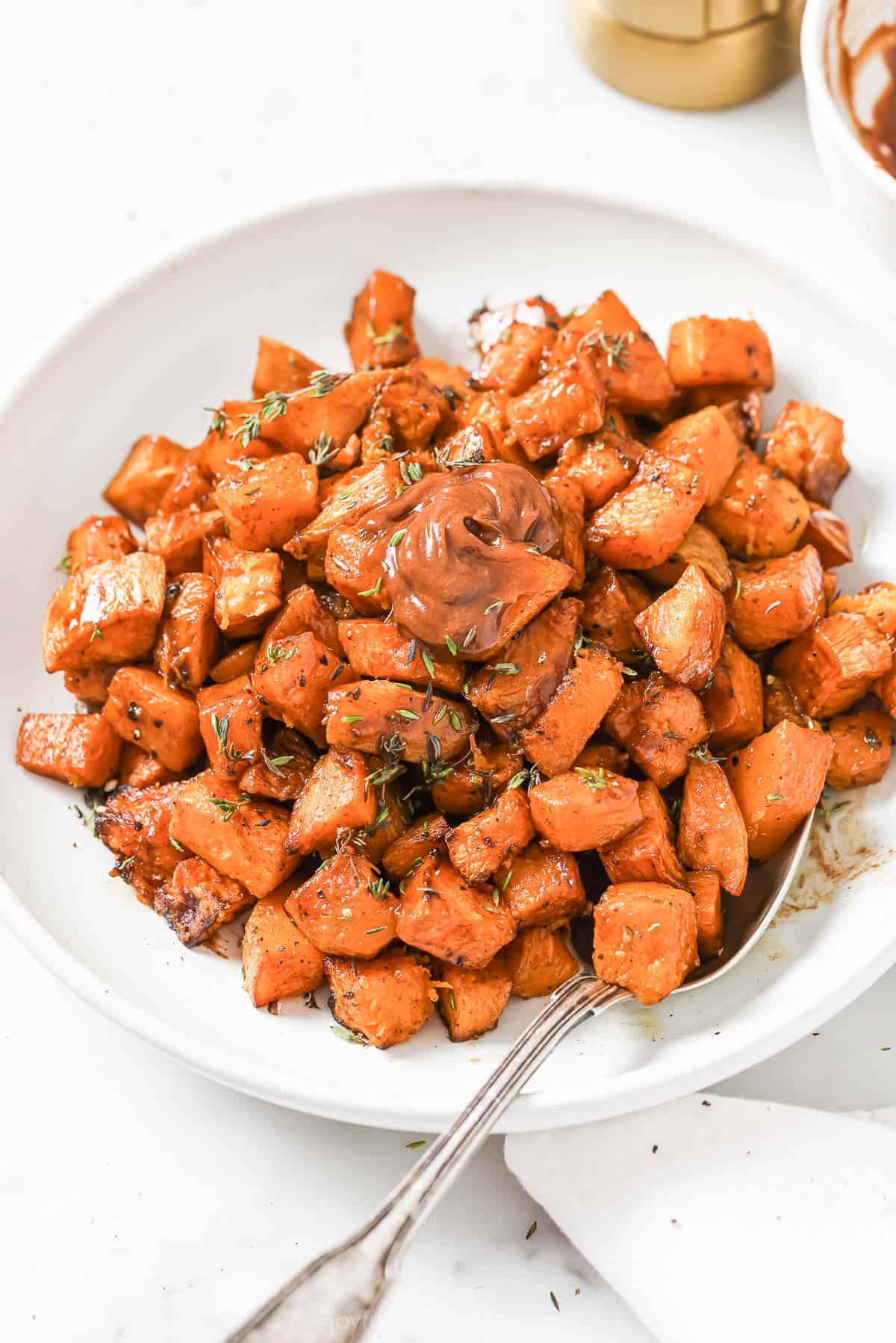 Butternut squash and sweet potato hash with cinnamon butter in a serving bowl. 