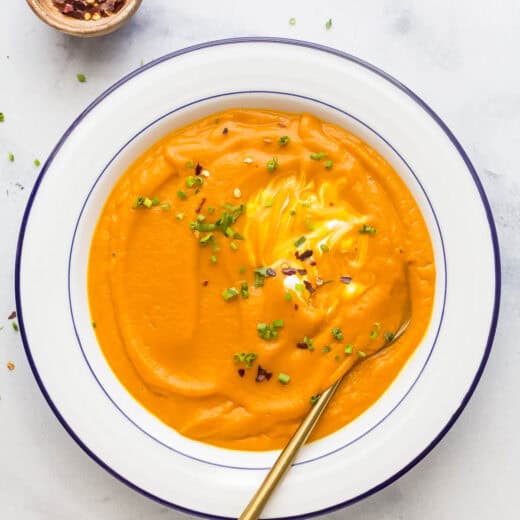 A bowl of silky puréed roasted carrot soup with ginger.