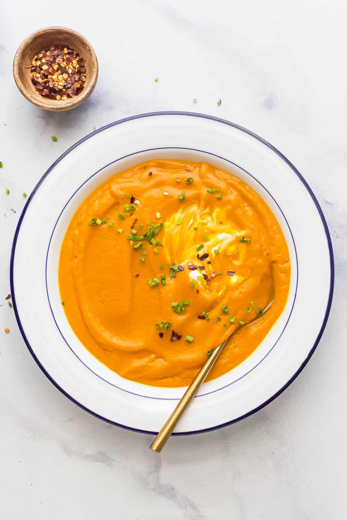 A bowl of silky puréed roasted carrot soup with ginger. 