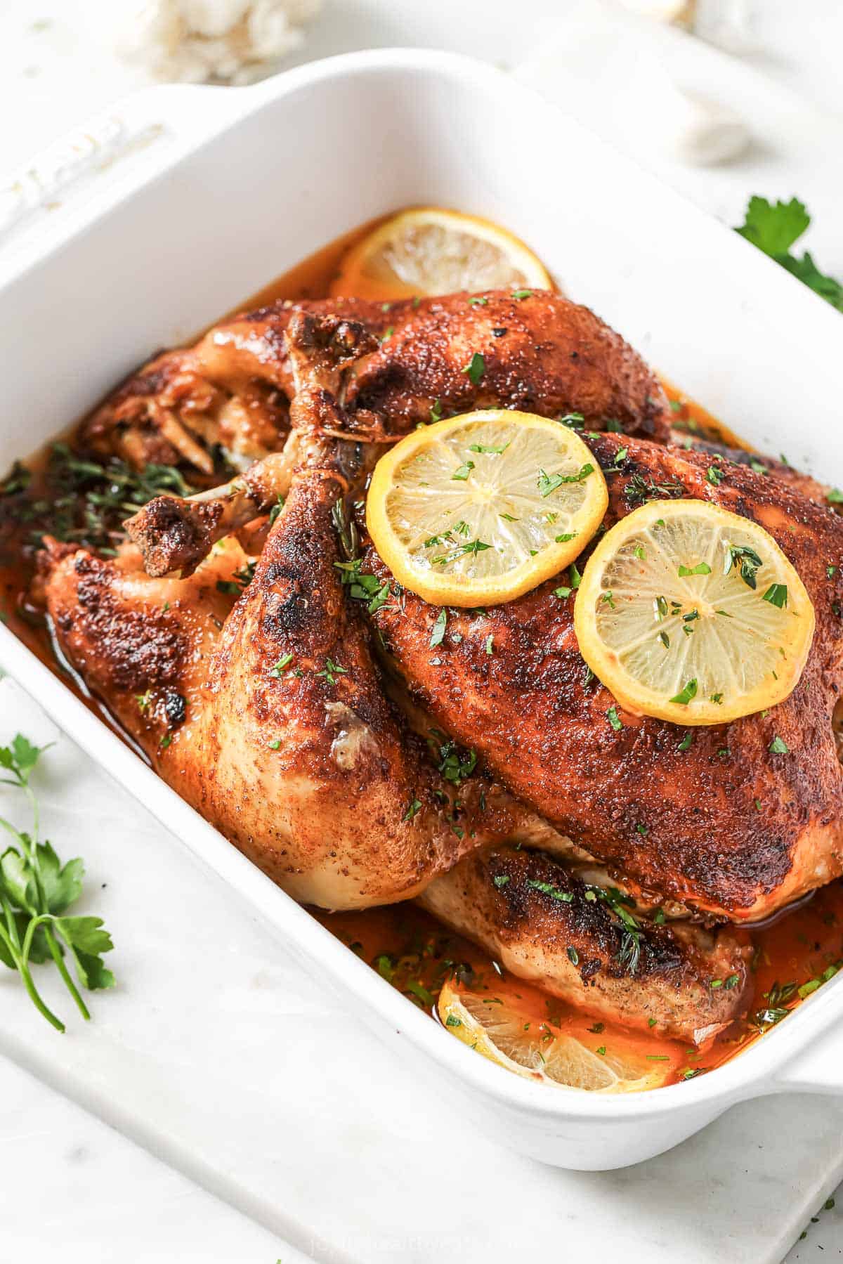 A recipe for cooking a whole chicken in the crockpot with two lemon wedges on top.