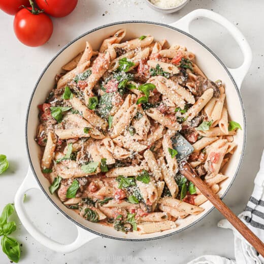 Landscape photo of tomatoey spinach mushroom pasta.