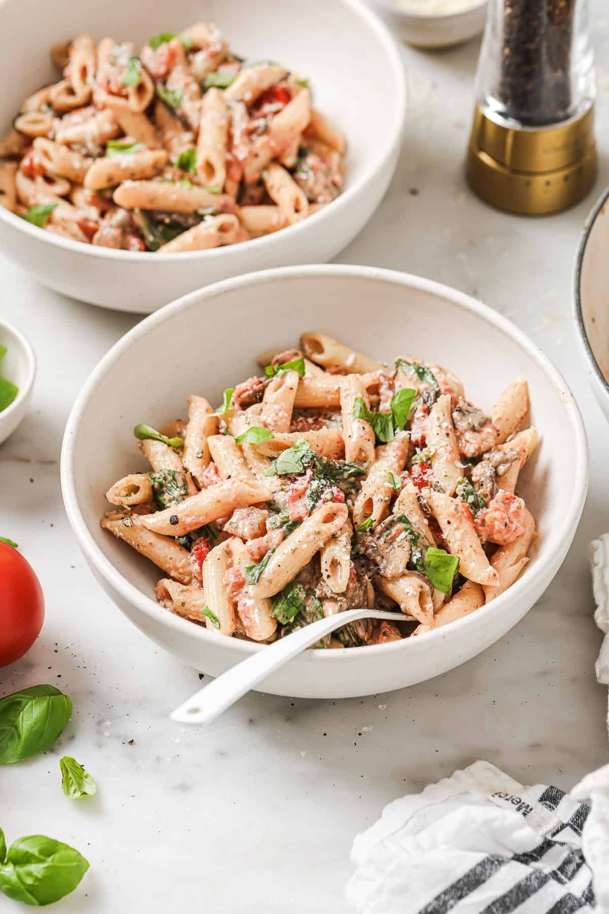 Bowl of homemade Italian pasta with creamy tomato sauce and sautéed veggies. 