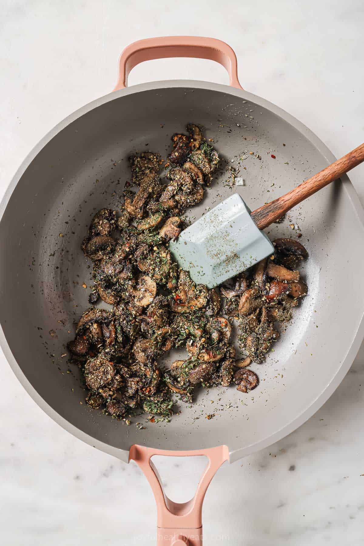 Sautéed mushrooms with herbs in the skillet. 