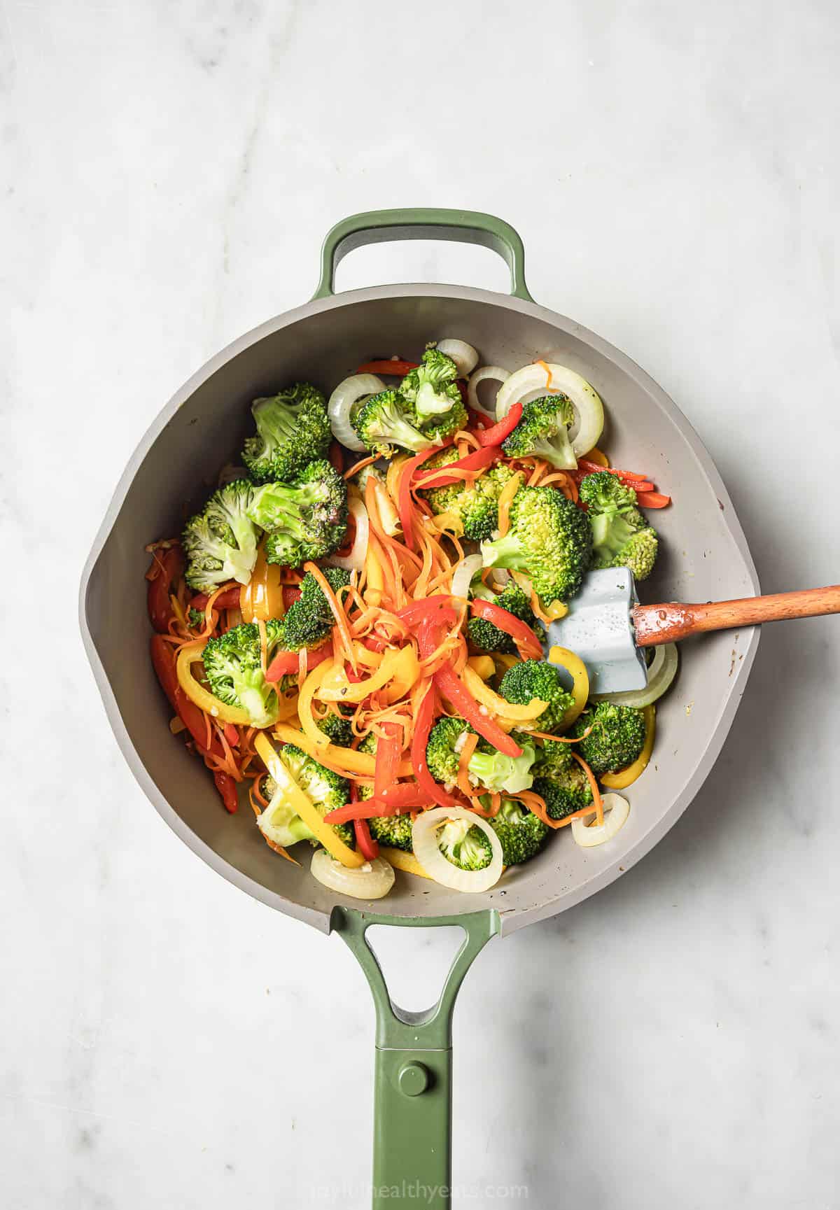 Stir frying the veggies in the skillet. 