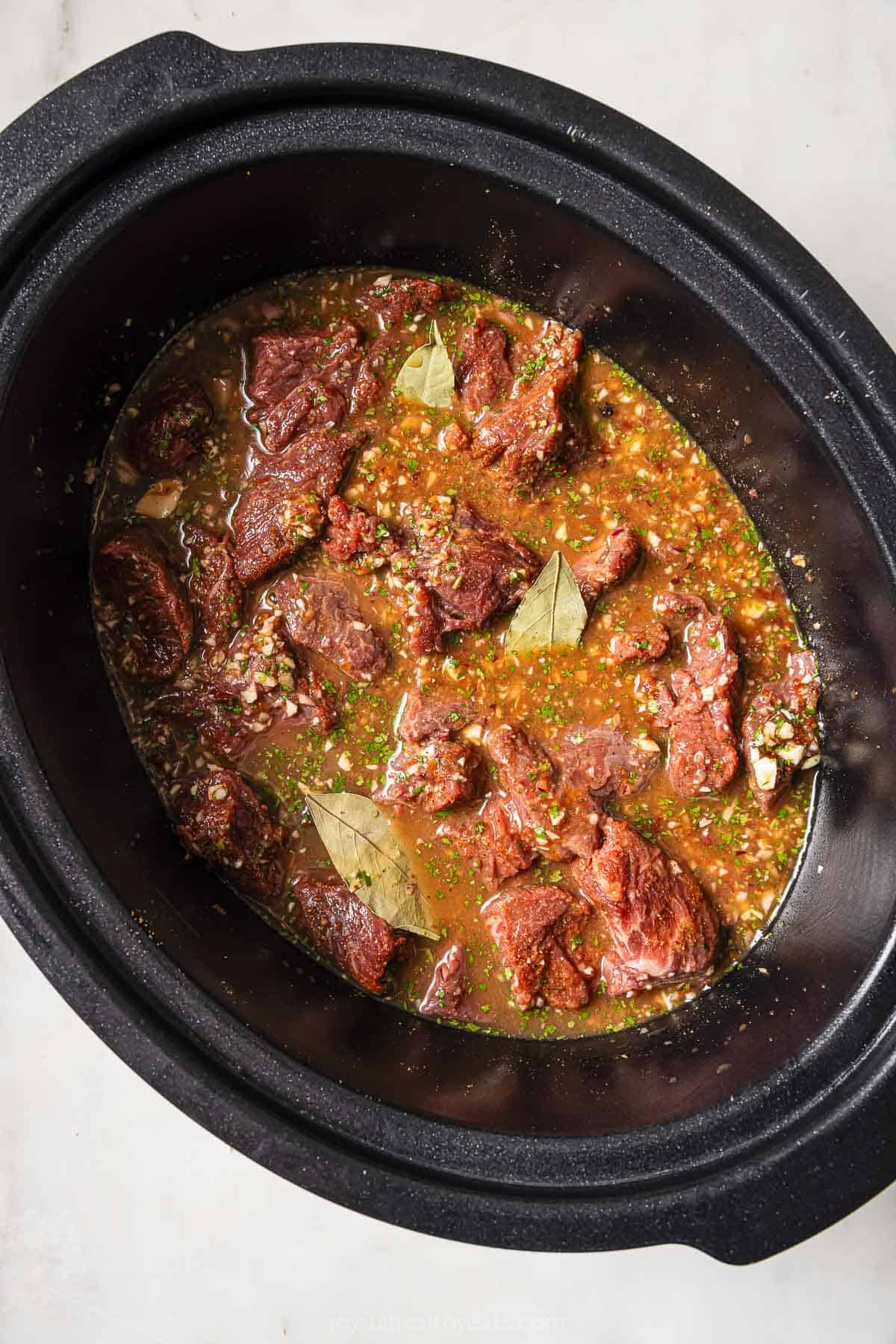 Adding the beef and sauce to the crockpot. 