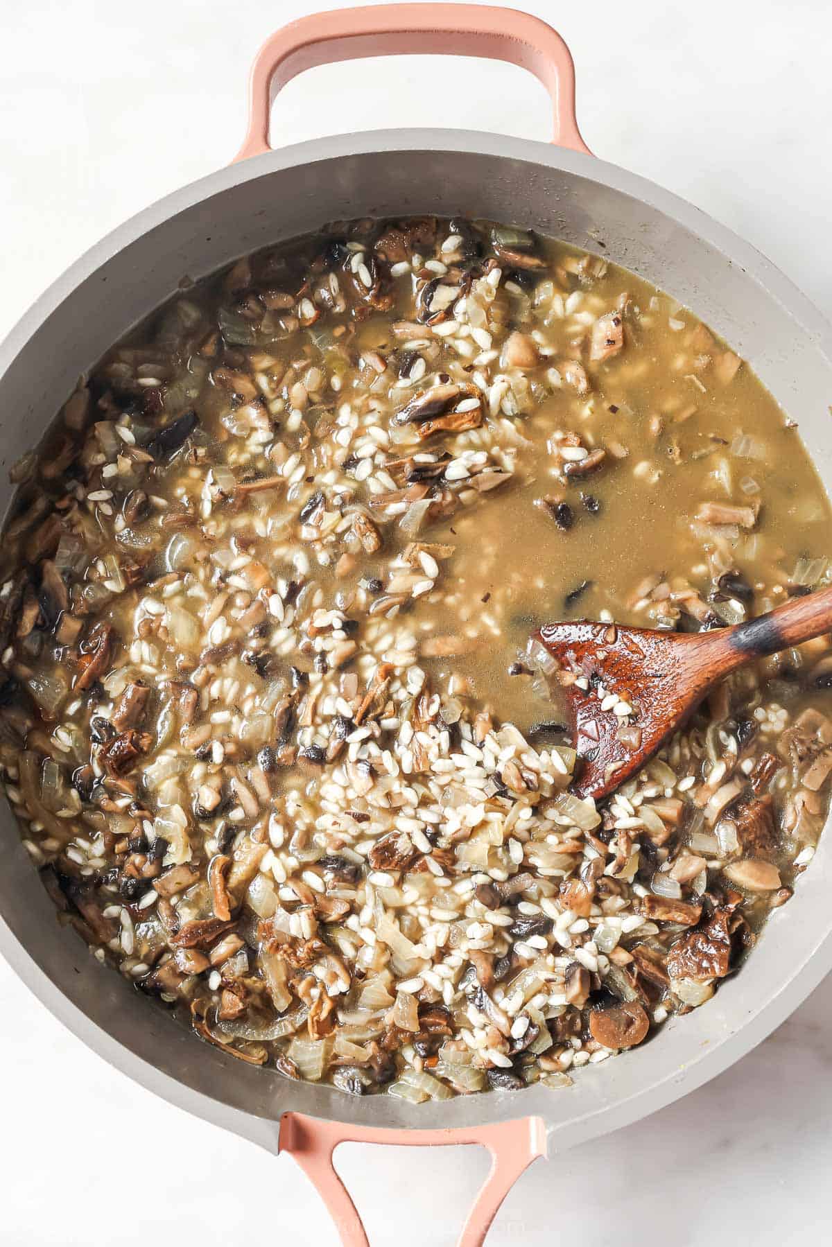 Stirring the broth into the rice.