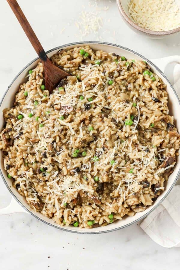 Big bowl of mushroom risotto with garlic, onions, white wine, parmesan, and peas.