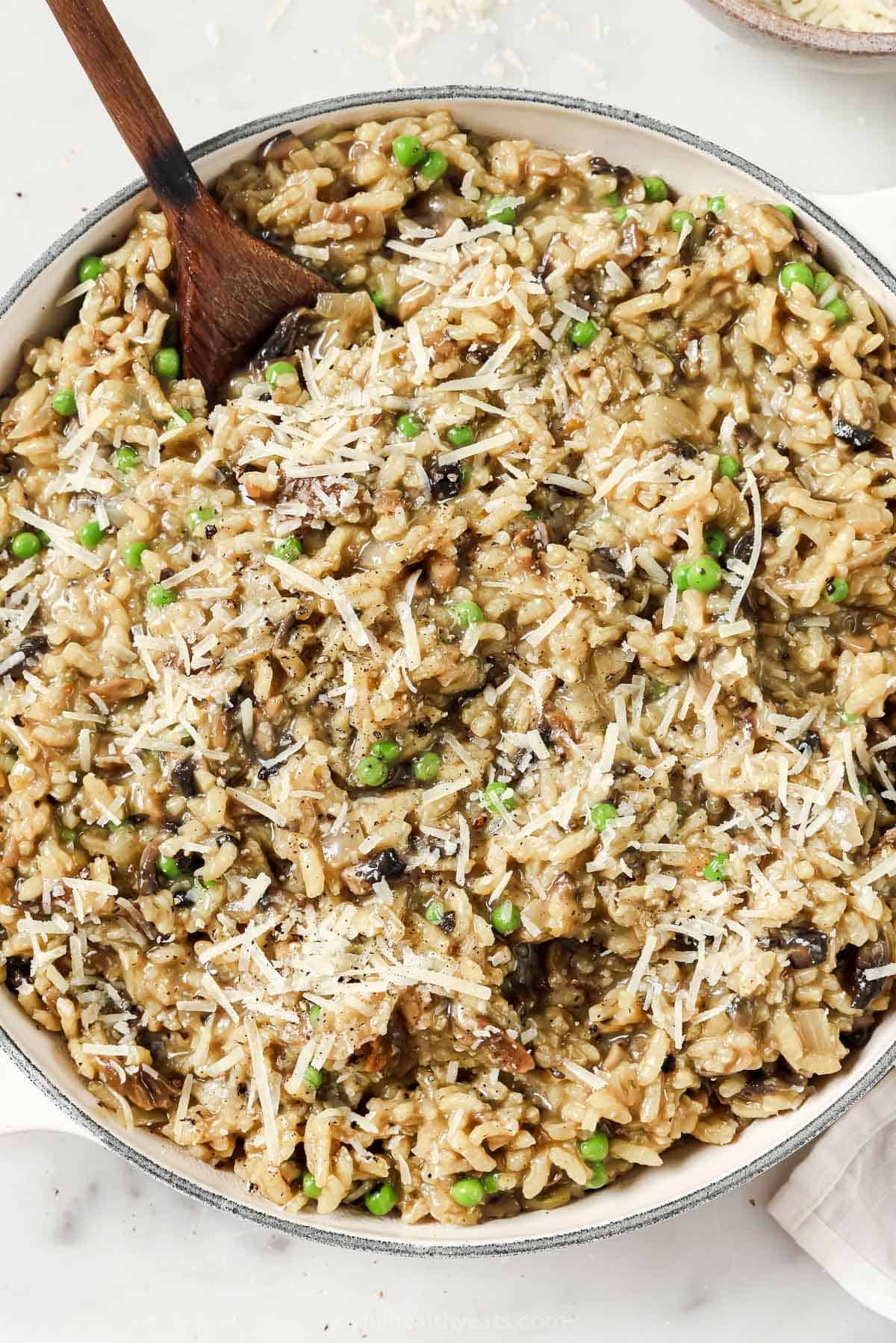 Large bowl of wild mushroom risotto with peas and sautéed onions. 