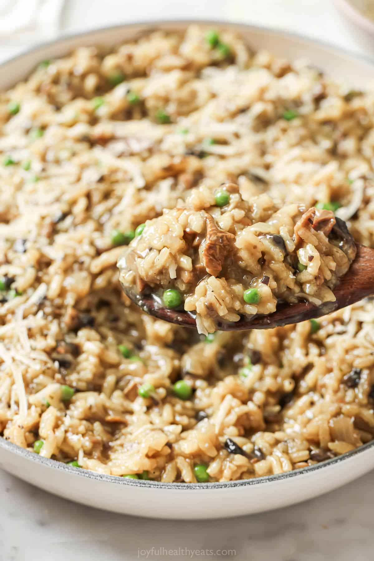 Close-up of tender risotto with melty parmesan, white wine, and mushrooms. 