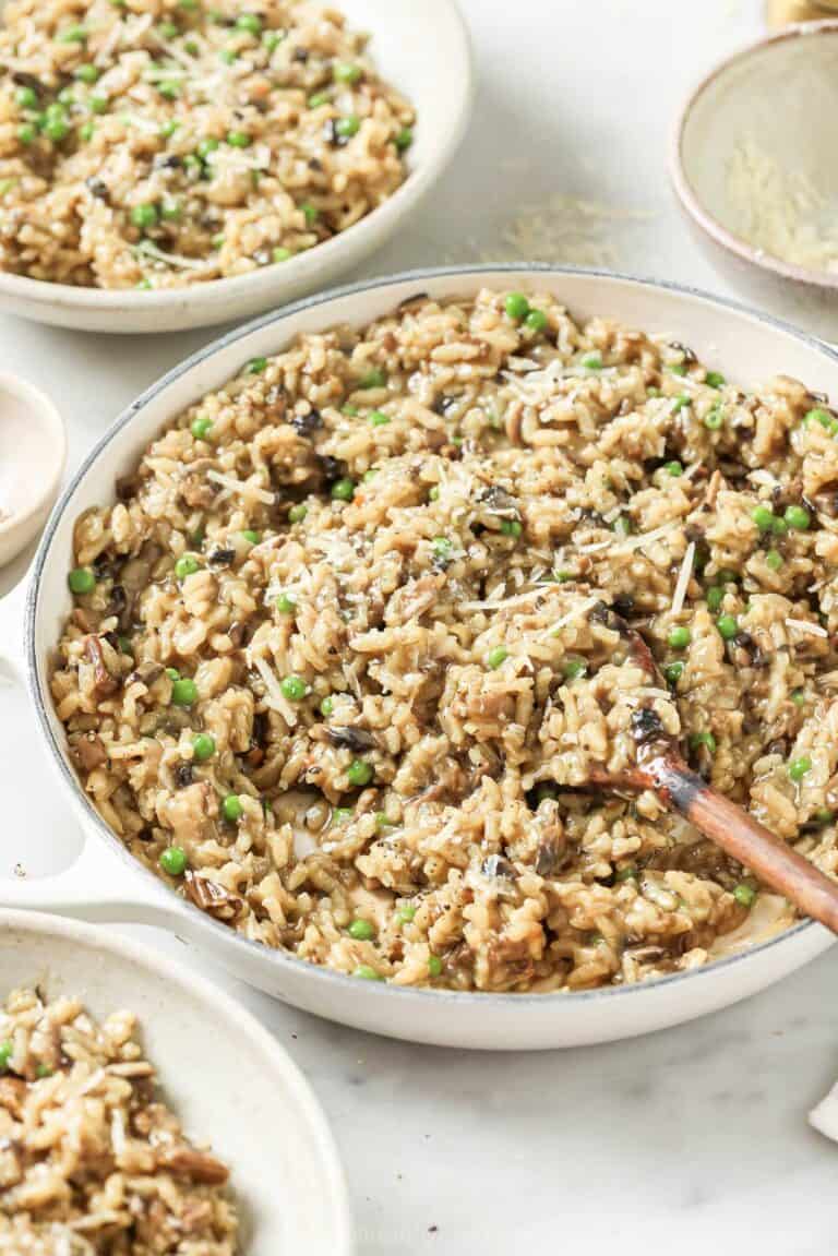 Wild mushroom risotto with chewy peas and parmesan cheese in a serving bowl.