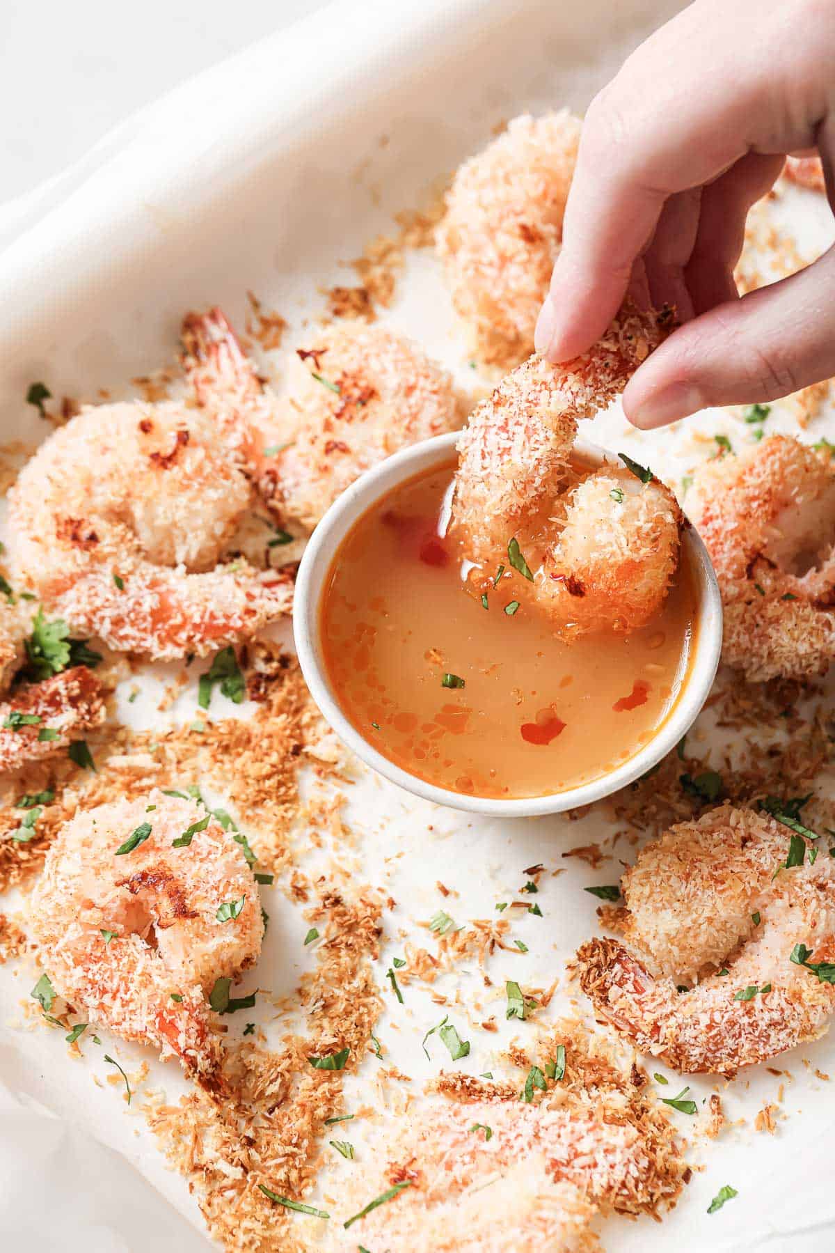 Dipping a coconut shrimp into garlic-ginger sauce. 