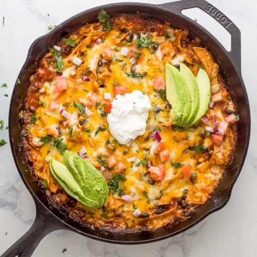 Cheesy chicken enchilada casserole with sour cream, avocado, and pico de gallo.