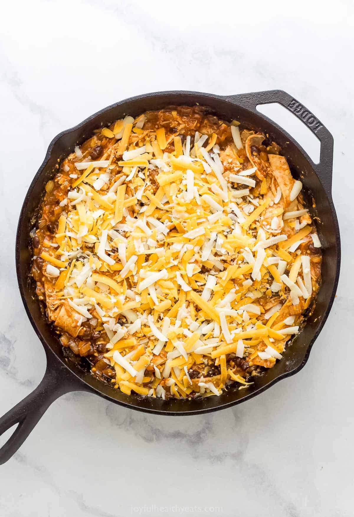 Sprinkling the cheese over the casserole mixture. 