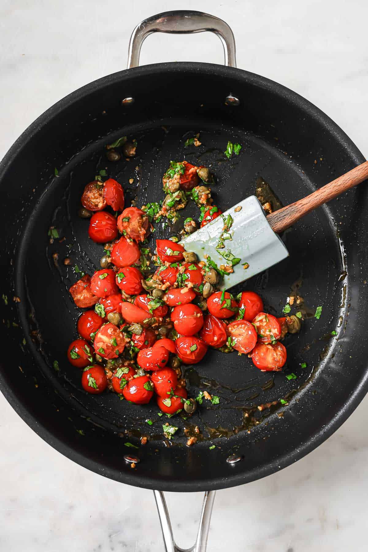 Fry the tomatoes, basil and capers in a wok. 