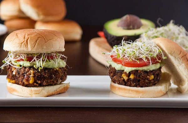 Chipotle Black Bean Freekeh sliders on bun with avocado spread, paradicsom és kelbimbó