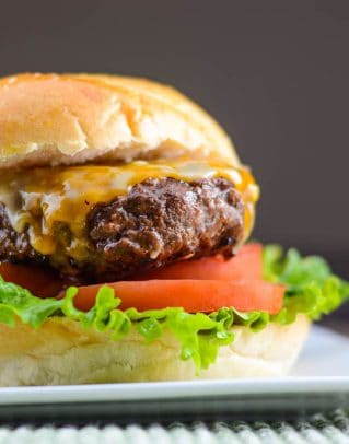 Asian barbecue burger på en bolle med sriracha mayo, salat, og tomat