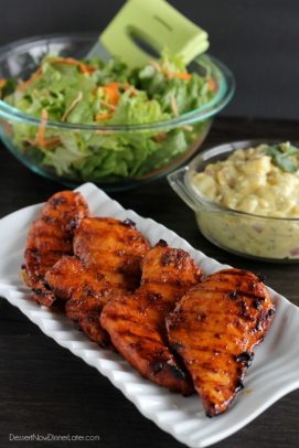 Pollo a la parrilla con miel picante pollo en un plato con un tazón de ensalada verde y ensalada de patatas