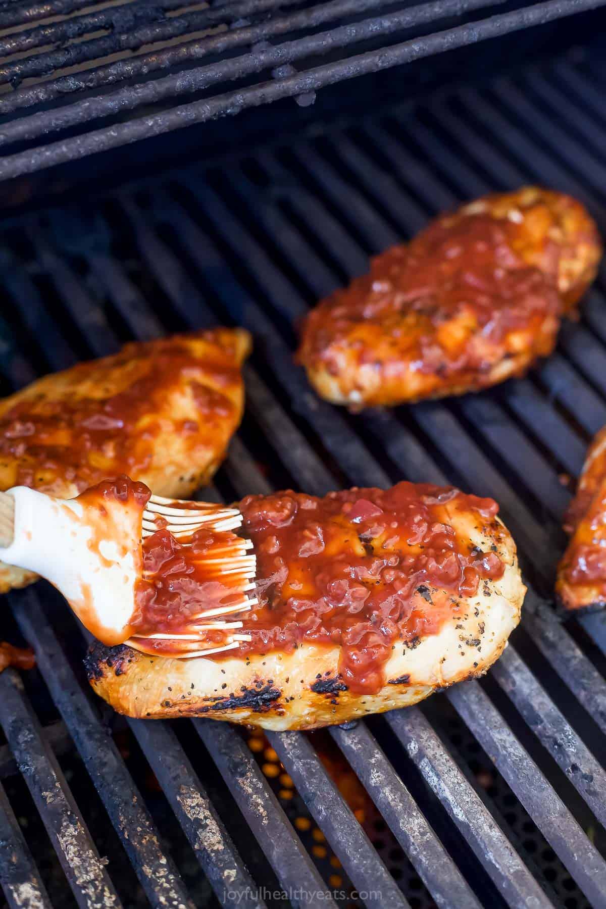 Brushing the chicken with raspberry BBQ sauce. 