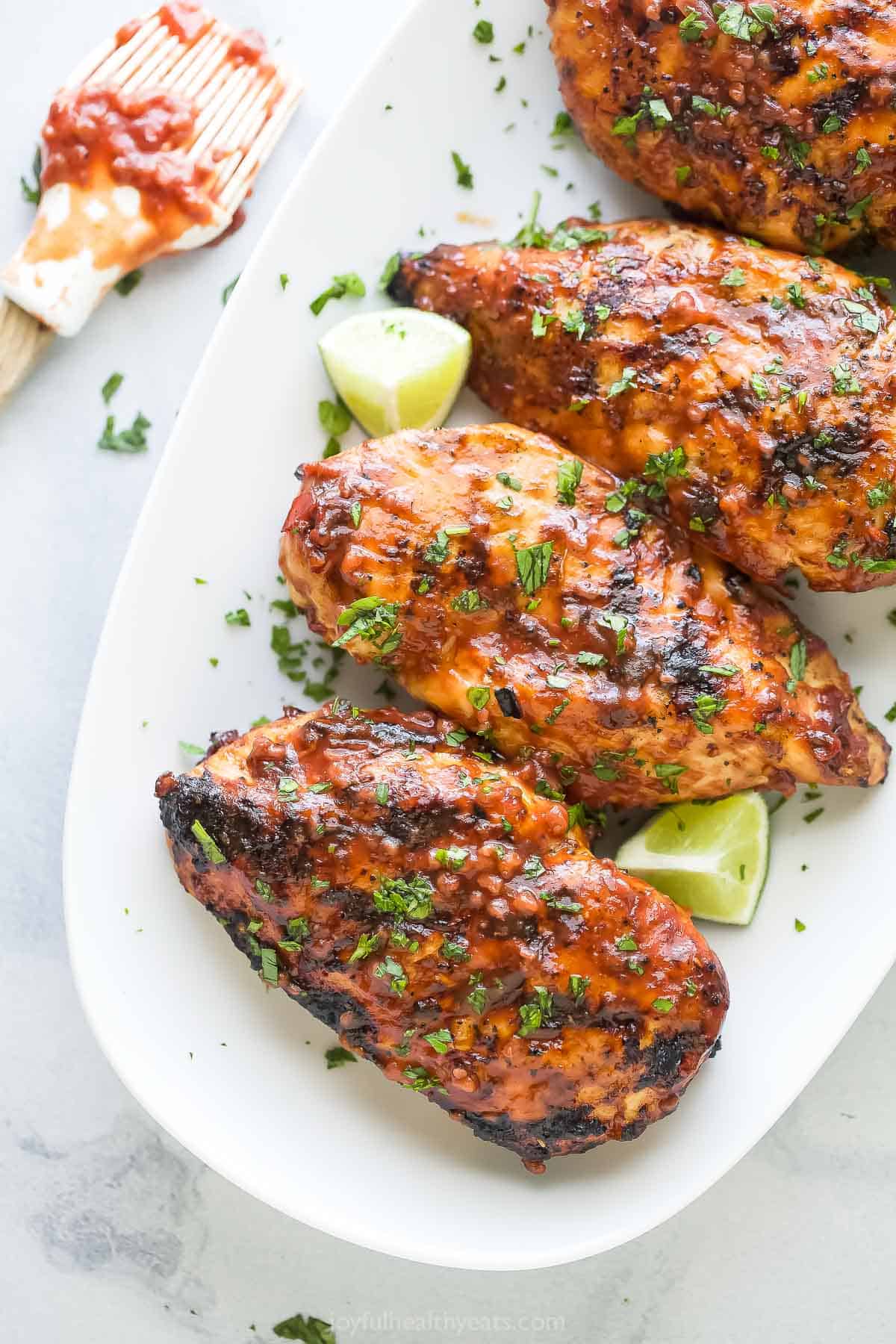 Grilled chicken with sweet and savory BBQ sauce, fresh cilantro, and lime wedges. 