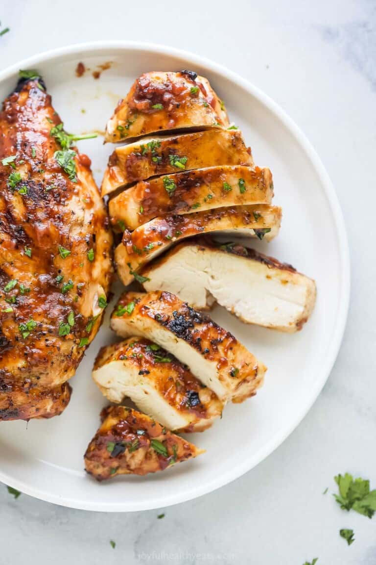 Juicy, sliced grilled chicken on a serving plate.