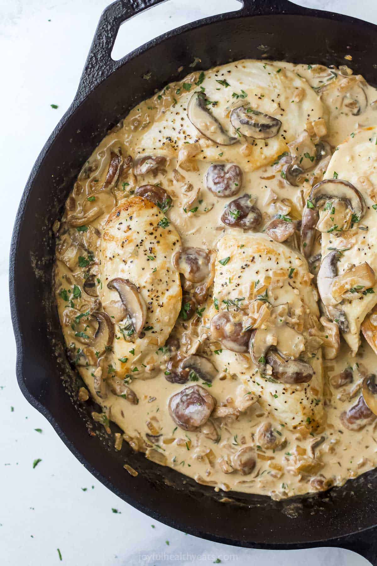 Creamy chicken with mushroom sauce and thyme in the skillet. 