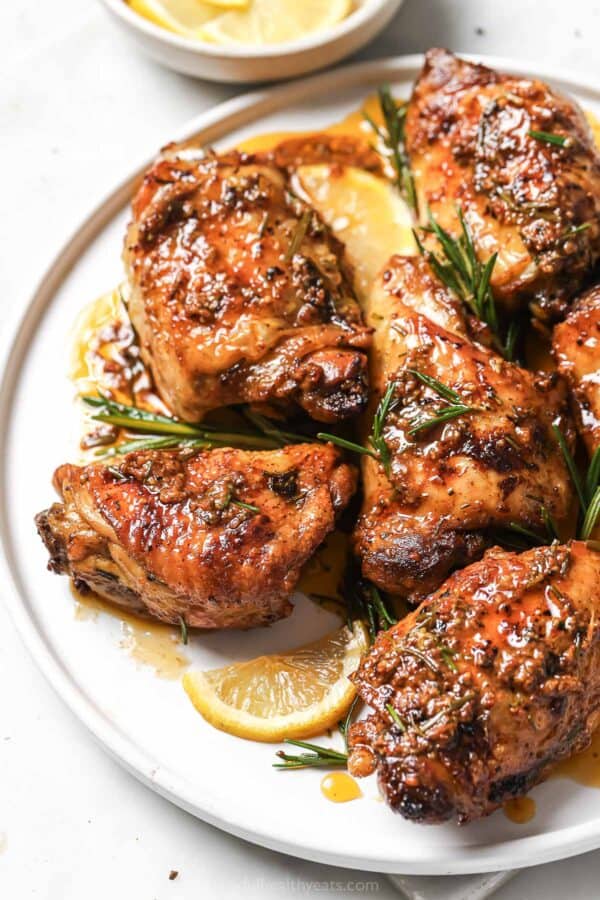 Serving plate with baked lemon rosemary chicken.