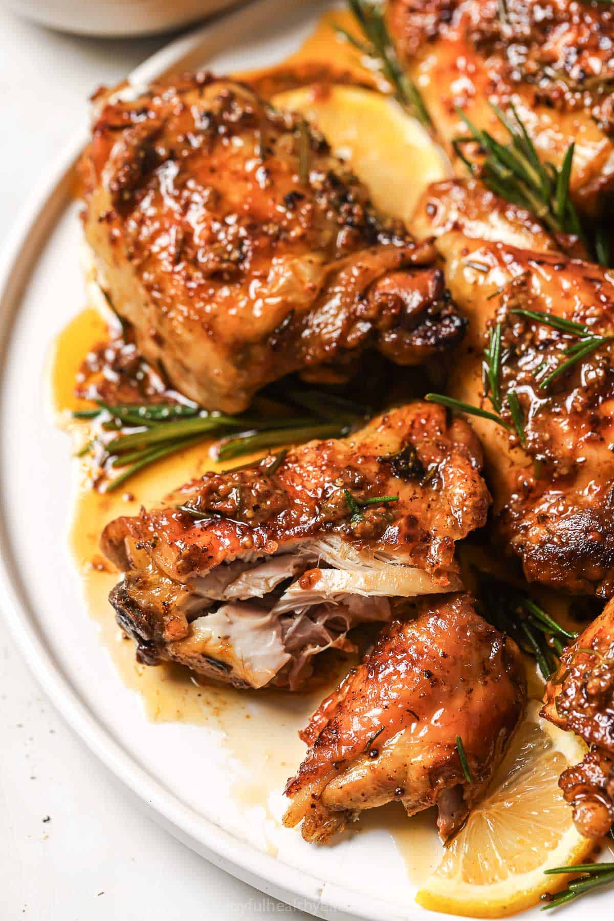 Close-up of the juicy lemon rosemary chicken thighs on a serving plate.