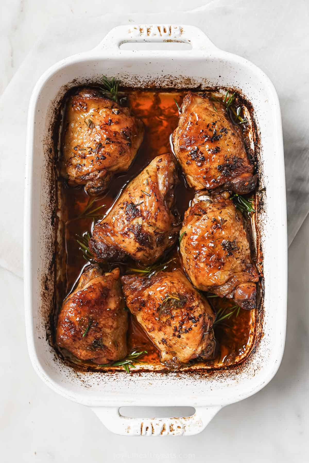 Baked chicken thighs in the baking dish.